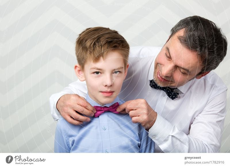Father helping son to adjust a bowtie. Preparation before important event Joy Happy Beautiful Child Human being Boy (child) Man Adults Parents