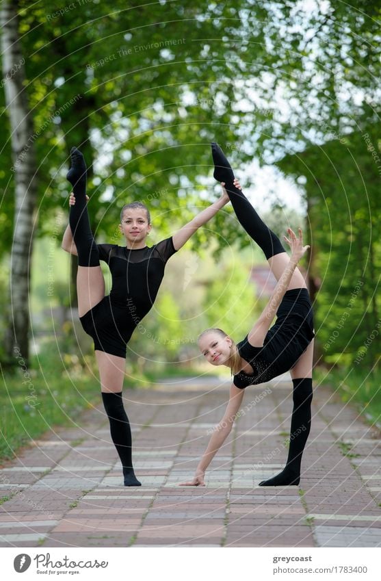 Two teen rhythmic gymnasts are showing their stretching and flexibility. Body Summer Sports Girl Youth (Young adults) 2 Human being Group Art Street Railroad