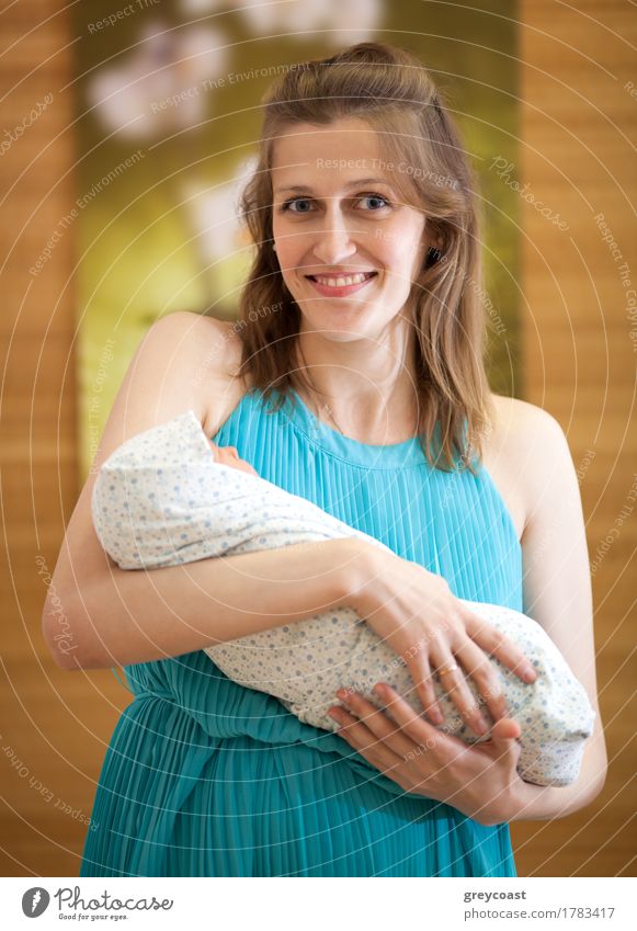 Happy new mother is holding newborn baby in arms. Life Child Baby Woman Adults Mother Family & Relations Arm 2 Human being Smiling Love Small New White Newborn