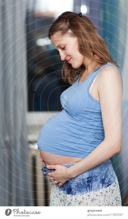 Pregnant woman stands in the room with her hands on belly Body Life Young man Youth (Young adults) Mother Adults Hand 1 Human being 18 - 30 years Brunette Touch