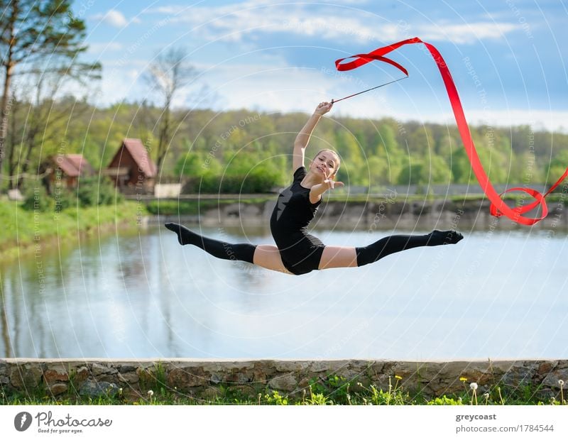 Young rhythmic gymnast doing split jump during ribbon exercises. Body Summer Sports Human being Feminine Girl Youth (Young adults) 1 13 - 18 years Railroad