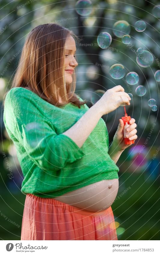 Smiling pregnant woman enjoying the time with blowing bubbles outdoor. Happy and healthy pregnancy Joy Relaxation Leisure and hobbies Summer Human being Girl