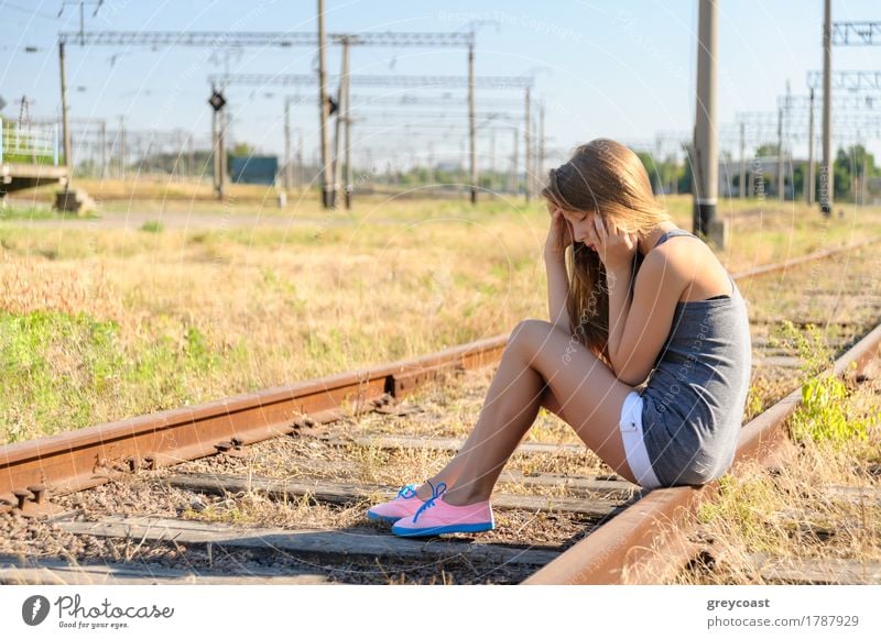 Sad girl teenager sitting on rusty rail track outside the town. Escape to be alone Summer Girl Woman Adults Youth (Young adults) Landscape Small Town Railroad