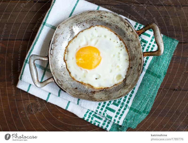 Fried egg in a old frying pan Herbs and spices Eating Breakfast Pan Table Fresh White Cholesterol Frying fried egg Meal Protein Rustic Unhealthy Close-up