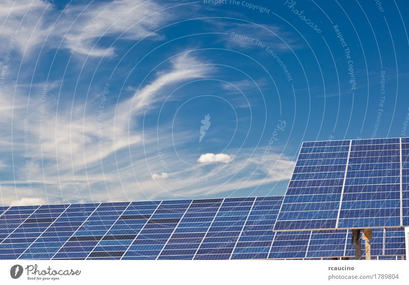 Photovoltaic panels in a solar power plant over a blue sky. Industry Solar Power Environment Sky Clouds Climate Natural Clean Blue Green Energy Alternative
