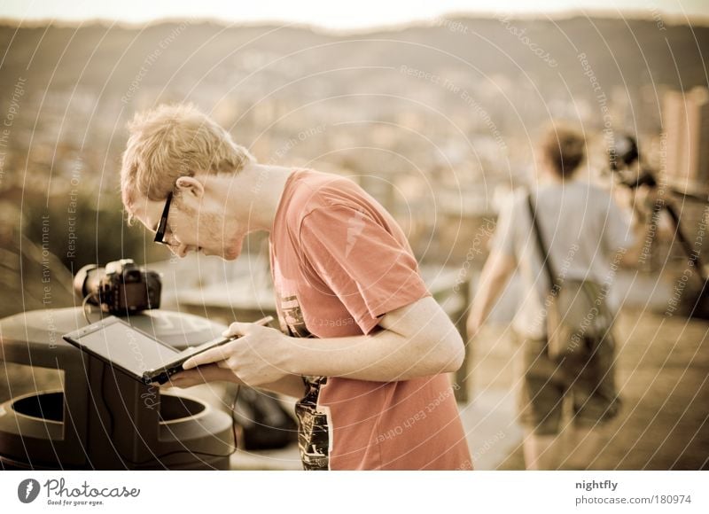 finding views Colour photo Subdued colour Exterior shot Evening Shallow depth of field Upper body Downward Notebook Camera Human being Man Adults 2