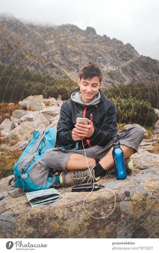 Boy resting on a rock and charging a mobile phone Bottle Lifestyle Leisure and hobbies Vacation & Travel Tourism Trip Adventure Freedom Summer Summer vacation
