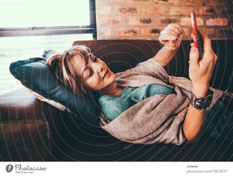 Modern mature woman laying on couch browsing internet Relaxation Living room Cellphone PDA Internet Woman Adults Comfortable Digital touch screen social media