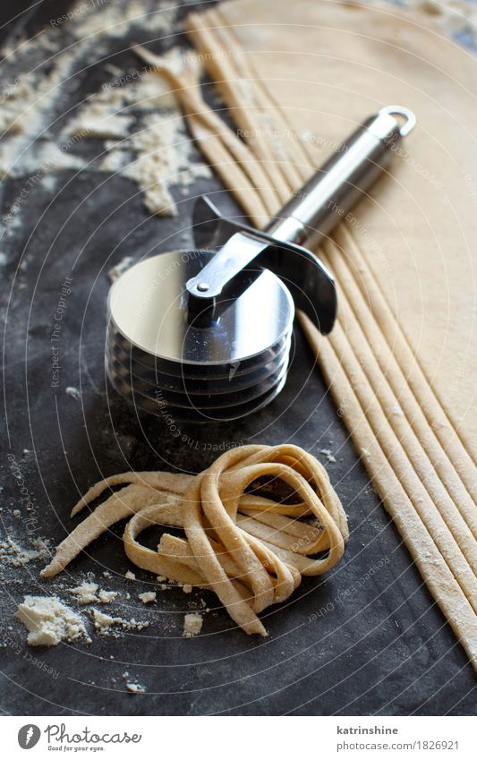 Making homemade taglatelle with a pasta rolling cutter Dough Baked goods Nutrition Italian Food Table Kitchen Tool Make Dark Fresh Tradition Ingredients manual