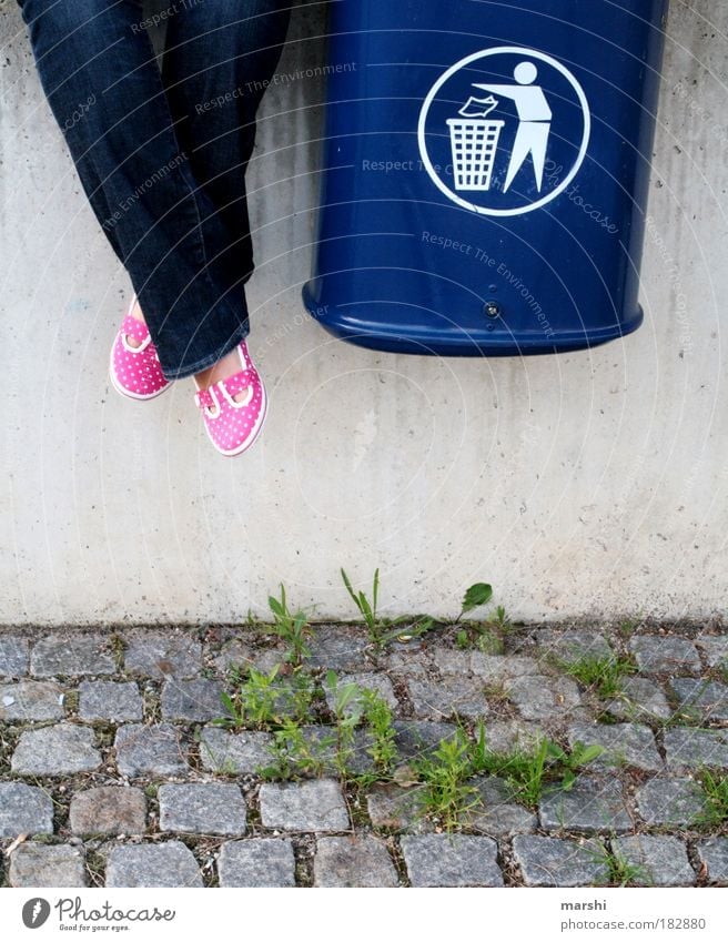 GARBAGE Colour photo Exterior shot Legs Feet Sit Trash container Pink Blue Grass Gravel path Wall (barrier) Arrange Recycling Recycling container Contrast Weed