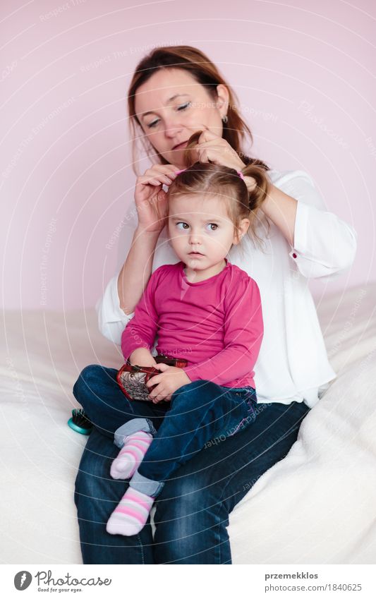 Mother doing her little daughter's hair. Family at home. Everyday life Beautiful Hair and hairstyles Child Baby Toddler Girl Woman Adults Parents