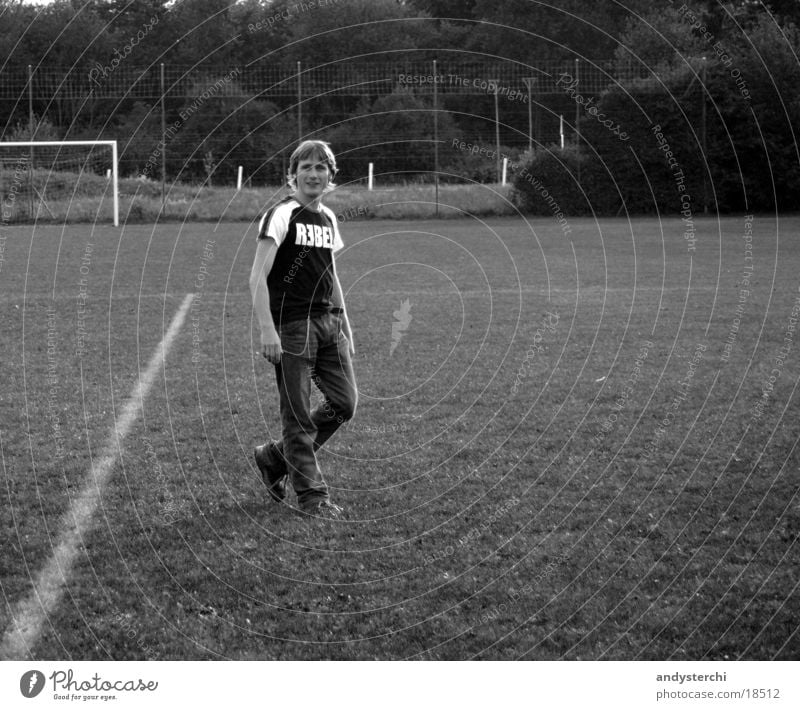 REBEL Football pitch Meadow Stand Blonde Man rebel T-shirt Black & white photo Cool (slang) Gate Signs and labeling crossed legs