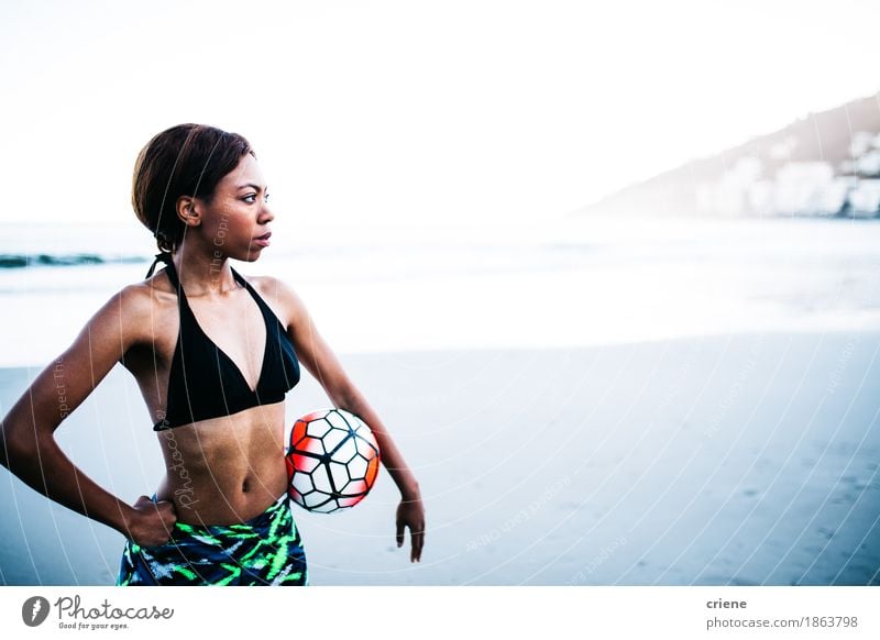 African female athlete holding soccer ball in hands Lifestyle Beautiful Body Athletic Fitness Relaxation Leisure and hobbies Playing Beach Sports Ball sports