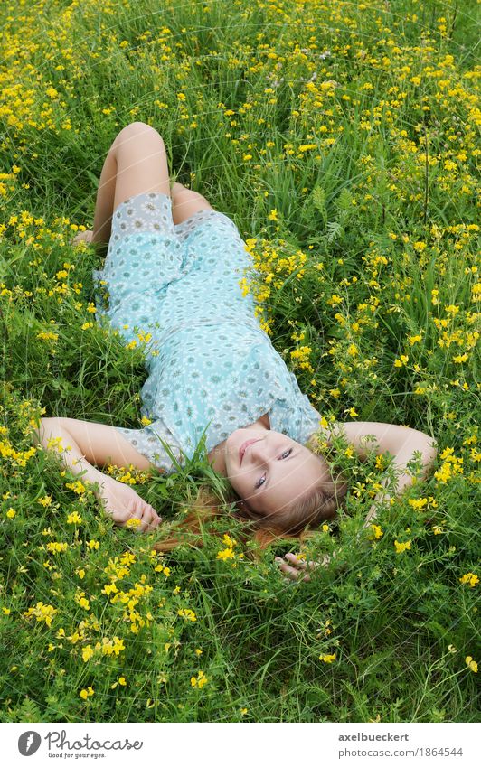 young woman lies upside down on a flower meadow Lifestyle Joy Contentment Relaxation Leisure and hobbies Human being Feminine Girl Young woman