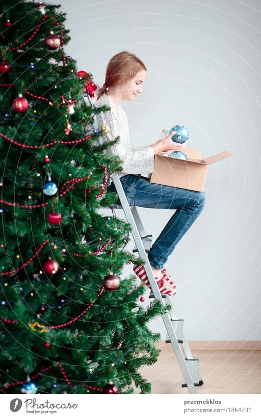 Young girl decorating Christmas tree with balls at home Lifestyle Joy Decoration Feasts & Celebrations Christmas & Advent Human being Child Girl 1 8 - 13 years