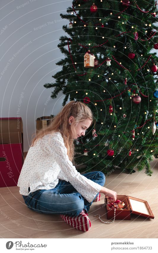 Young girl decorating Christmas tree at home Lifestyle Joy Decoration Feasts & Celebrations Christmas & Advent Human being Child Girl 1 8 - 13 years Infancy