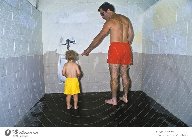 Father and son in public restroom. Boy (child) Adults 1 - 3 years Toddler Swimming trunks Urinal Help Responsibility Conscientiously Curiosity Concern Stress