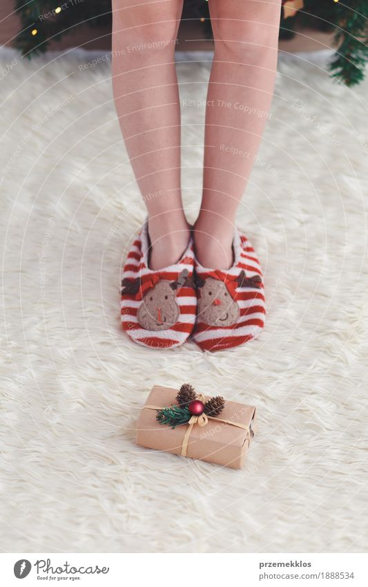 Girl standing by Christmas gift put near tree Lifestyle Feasts & Celebrations Christmas & Advent Child Human being Legs 1 Dress Red Anonymous Carpet christmas