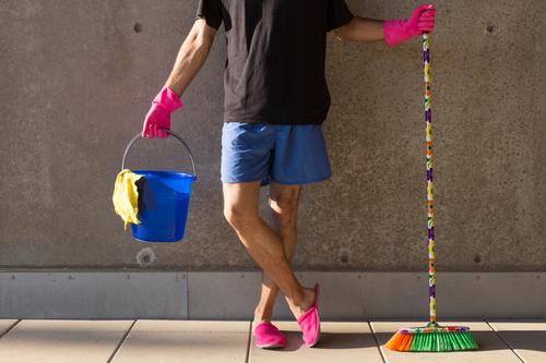 A househusband in pink slippers and cleaning utensils Summer Masculine Man Adults Body 1 Human being 30 - 45 years Wall (barrier) Wall (building) Slippers Broom