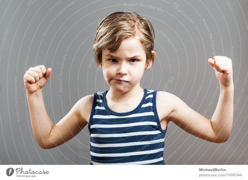 Six-year-old boy shows his biceps muscles Face Sports Success Child Human being Toddler Boy (child) 3 - 8 years Infancy Growth Athletic Cool (slang) Strong Gray