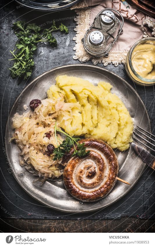 Bratwurst with mashed potatoes and sauerkraut Food Sausage Vegetable Lettuce Salad Herbs and spices Nutrition Lunch Dinner Banquet Crockery Plate Cutlery Style