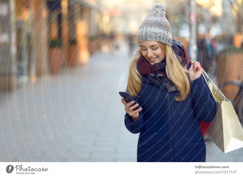 Fashionable young woman busy with her mobile phone Lifestyle Beautiful Reading Winter Telephone PDA Technology Woman Adults 1 Human being 18 - 30 years