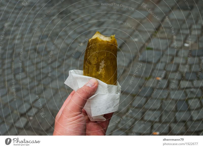 Cucumber in the hand on cobblestone feasting Healthy Eating Life Contentment Senses Hand Fingers Munich Tourist Attraction Street To enjoy Authentic Appetite