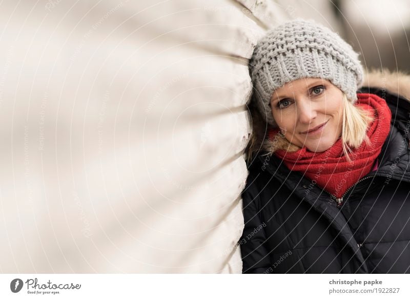 Red bowl / Grey cap Young woman Youth (Young adults) Woman Adults Face 1 Human being 30 - 45 years Wall (barrier) Wall (building) Coat Scarf Cap Blonde Smiling