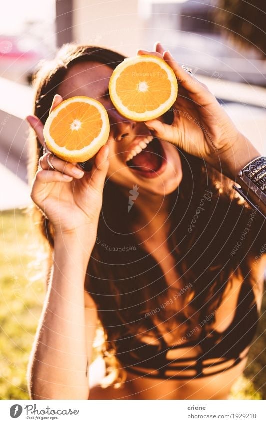 Young women holding oranges in front of her face Food Fruit Orange Lifestyle Joy Relaxation Summer Summer vacation Sun Sunbathing Garden Feminine Young woman