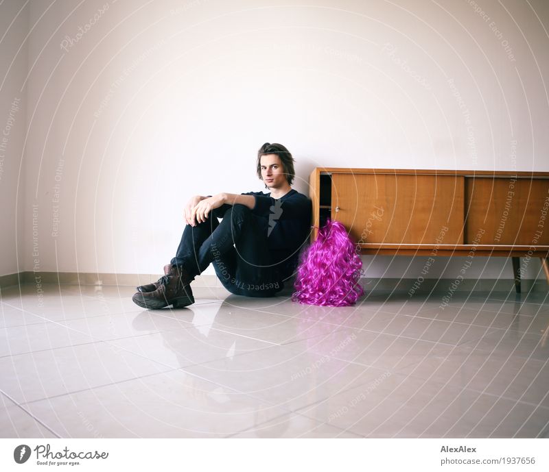 young man sitting at a sideboard in a bright room next to a purple wig Lifestyle Style Joy Night life Party Young man Youth (Young adults) 18 - 30 years Adults