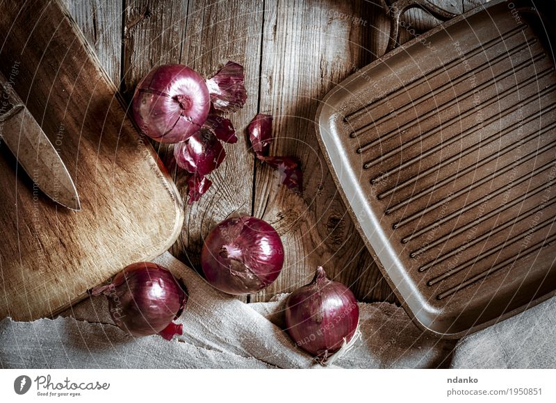 Black pan for the grill and red onion on a wooden surface Vegetable Vegetarian diet Pan Knives Kitchen Cloth Wood Metal Old Dark Fresh Brown Gray Red Onion