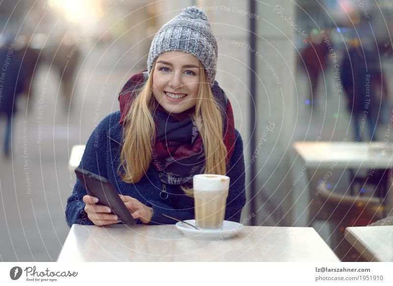 Young blond woman with mobile drinking coffee Drinking Coffee Latte macchiato Lifestyle Happy Beautiful Face Reading Winter Table Technology Woman Adults 1