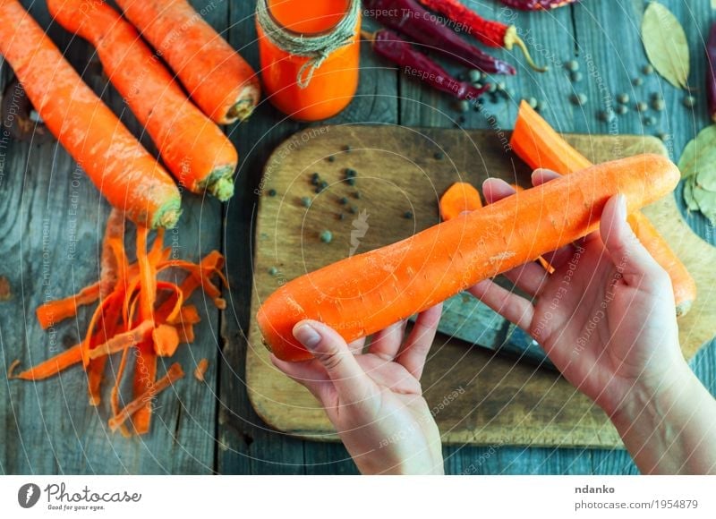 Large fresh carrots in a female hand Vegetable Herbs and spices Nutrition Eating Vegetarian diet Diet Beverage Juice Bottle Table Woman Adults Hand Fingers 1