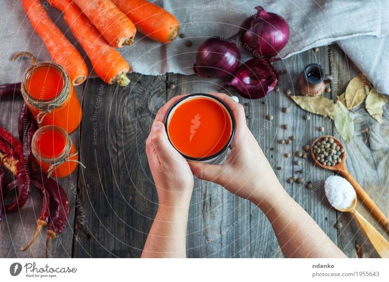 Iron mug with carrot juice in female hands Food Vegetable Herbs and spices Nutrition Beverage Cold drink Juice Cup Spoon Table Woman Adults Hand 1 Human being