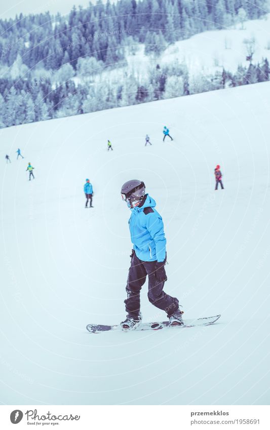 Boy riding a snowboard down the slope Joy Vacation & Travel Winter Snow Winter vacation Mountain Sports Snowboard Boy (child) Nature Landscape Hill