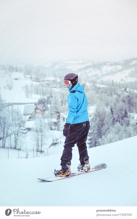 Boy riding a snowboard down the slope Lifestyle Joy Vacation & Travel Winter Snow Winter vacation Mountain Sports Snowboard Boy (child) Nature Landscape Hill