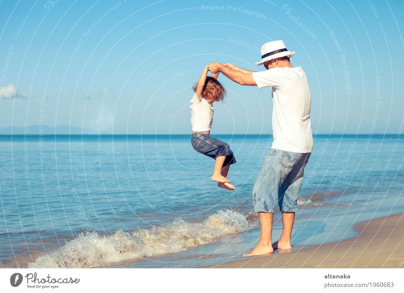 Father and son playing on the beach at the day time. Concept of friendly family. Lifestyle Joy Relaxation Leisure and hobbies Playing Vacation & Travel Trip