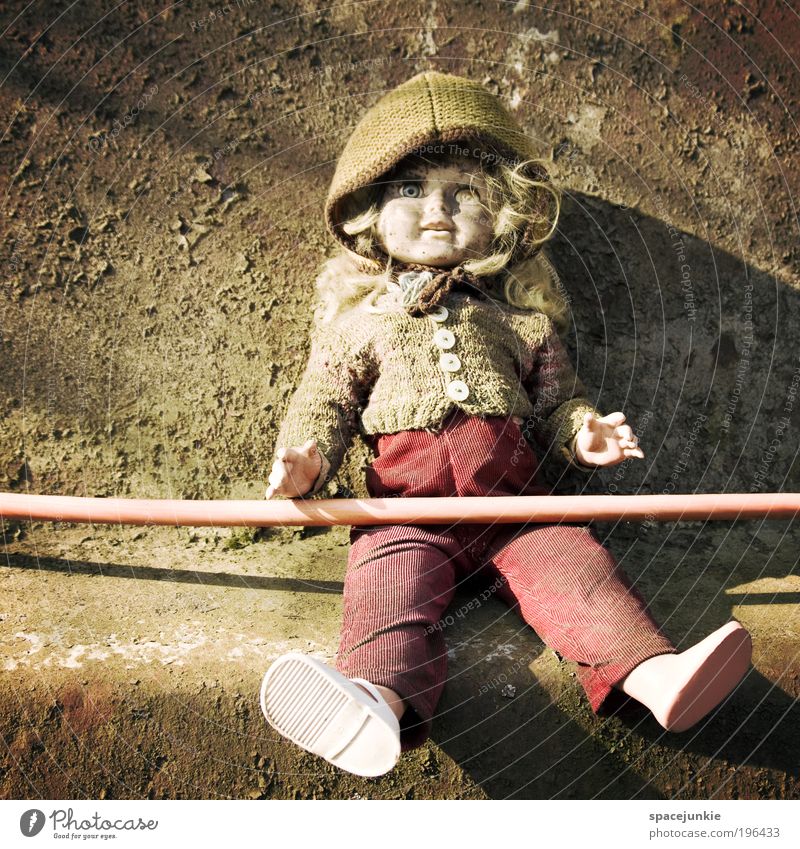 The doll from the scrap yard Footwear Cap Old Hideous Loneliness Doll Toys Sit Whimsical Creepy Child Hose Dirty Wall (barrier) Bleak Colour photo Exterior shot