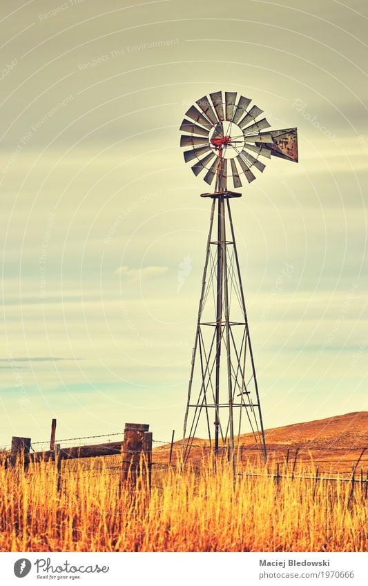 An old western windmill tower. Sky Autumn Wind Grass Field Old Retro Energy Western Farm Windmill Rural Wild West America background agriculture USA