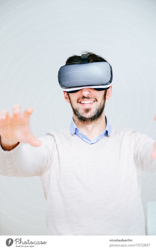 Man with VR glasses searches and smiles virtual reality Joy Virtual Playing Computer games Expedition Success Office Media industry Business Meeting Headset