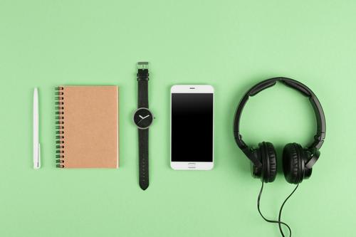 Smartphone, notepad, headphones on the color back Table Music Business Telephone PDA Computer Screen Technology Internet Media Paper Listening Above Green White