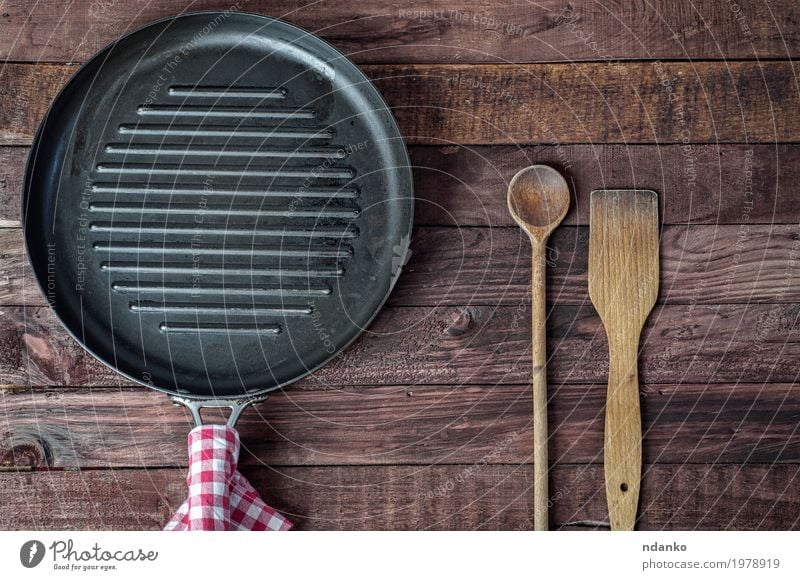 Empty grill pan and wooden cooking utensils Pan Spoon Table Kitchen Restaurant Cloth Wood Metal Above Brown Black tableware Tablecloth spatula Vantage point