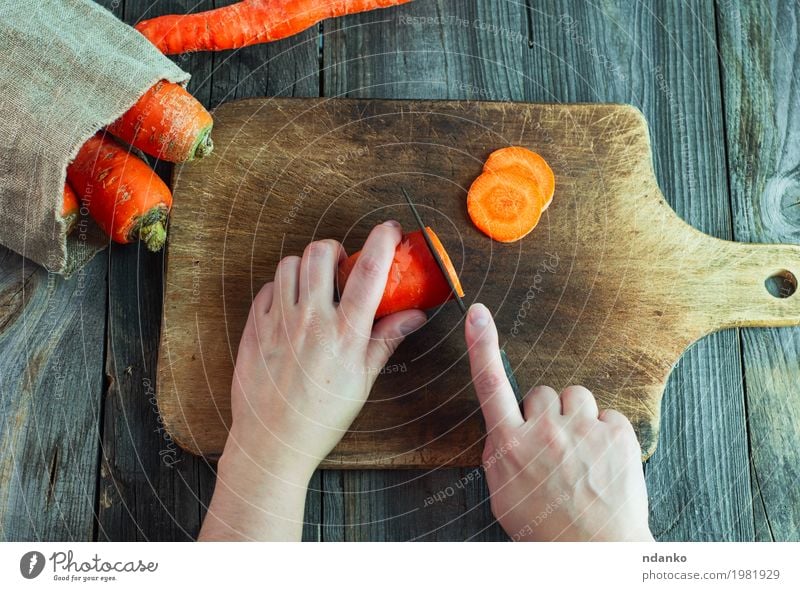 process of slicing carrots on slices on a kitchen board Food Vegetable Nutrition Eating Vegetarian diet Diet Knives Table Kitchen Woman Adults Hand Fingers 1