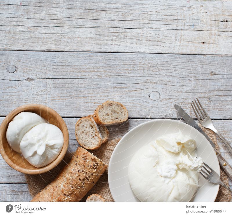 Italian cheese burrata with bread on a wooden background Cheese Bread Nutrition Vegetarian diet Italian Food Plate Bowl Knives Fork Wood Fresh Delicious Soft