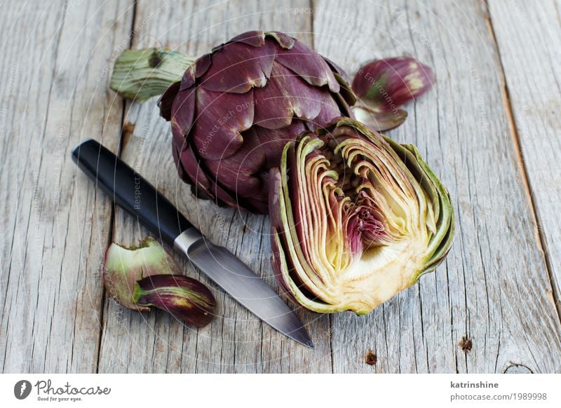 Roman Artichokes on a wooden board with knife Vegetable Nutrition Vegetarian diet Knives Fresh Gray Green agriculture Purple cooking Cut Edible food Half