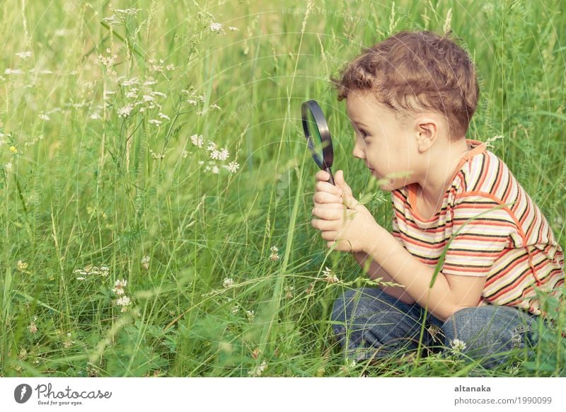 Happy little boy exploring nature with magnifying glass at the day time Lifestyle Joy Face Playing Summer Garden Science & Research Child School Human being