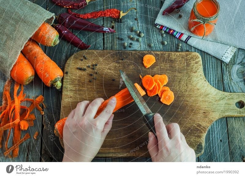 Sliced fresh carrots on a kitchen board Vegetable Herbs and spices Vegetarian diet Diet Beverage Juice Knives Table Kitchen Woman Adults Hand Fingers 1