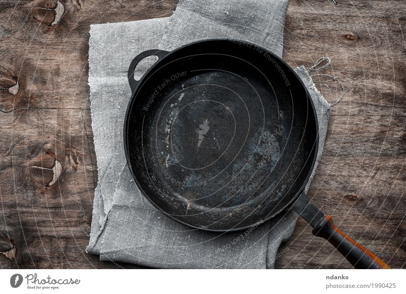 Empty black cast-iron frying pan Crockery Pan Table Kitchen Restaurant Cloth Wood Metal Above Clean Brown Black tableware Tablecloth Vantage point Frying