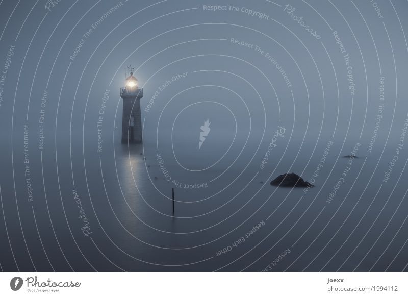 Lighthouse in the water in fog Water coast Fog coastal fog Safety Ocean Rock path tranquillity Orientation Sky Exterior shot Colour photo Deserted Night Evening