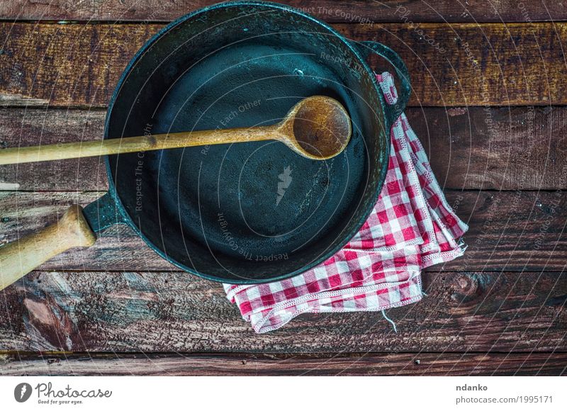 Empty black cast-iron frying pan Crockery Pan Spoon Design Table Kitchen Restaurant Cloth Wood Metal Above Clean Brown Black tableware Tablecloth spatula
